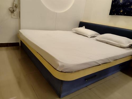 un letto con lenzuola e cuscini bianchi di Just homes 2 bhk Service appt a Pune