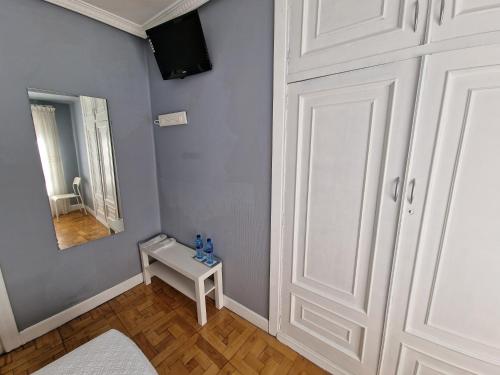Habitación con mesa blanca y espejo. en Hostal Fidalgo en Oviedo