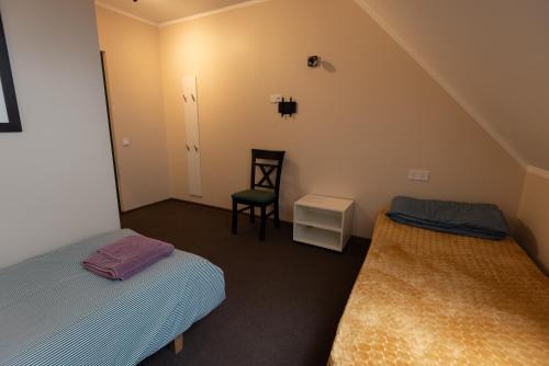 a small bedroom with two beds and a chair at Aiakeskuse hostel in Rakvere
