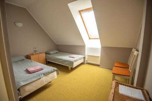 a attic room with two beds and a window at Aiakeskuse hostel in Rakvere