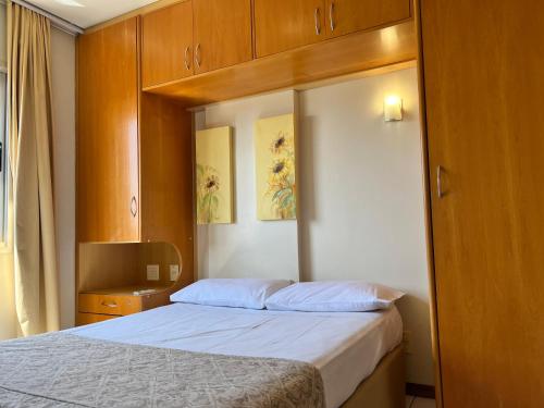 a small bedroom with a bed and a tv at Multiparque Hplus Long Stay in Brasilia