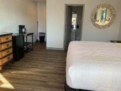 a bedroom with a bed and a dresser and a mirror at Outer Banks Motor Lodge in Kill Devil Hills