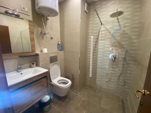 a bathroom with a shower and a toilet and a sink at Promenade 3-Bedroom apartment with large balcony. in Durrës