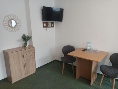 a room with a table and chairs and a television at Gościniec Silver in Toruń