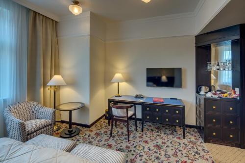 a hotel room with a bed and a desk at Hotel Savoy Prague in Prague