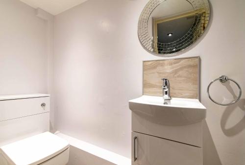 a white bathroom with a sink and a mirror at St Johns, Wakefield - Self check in & free parking in Wakefield