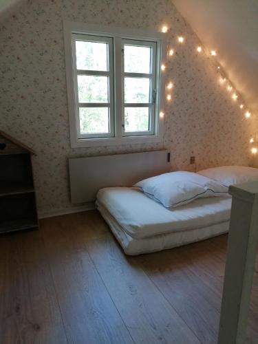 a bedroom with two beds and a window with lights at Skovhuset in Give