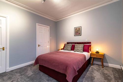 a bedroom with a bed with red pillows at St Johns, Wakefield - Self check in & free parking in Wakefield