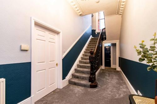 a hallway with a staircase with blue walls and a door at St Johns, Wakefield - Self check in & free parking in Wakefield