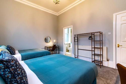 two beds in a room with blue sheets at St Johns, Wakefield - Self check in & free parking in Wakefield