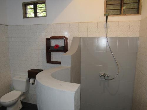 a bathroom with a bath tub and a toilet at Furaha Lodge in Jambiani