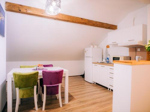 a kitchen with a table and chairs in a room at Apartman Aleksandar lux in Palić
