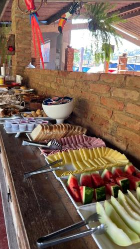 a buffet line with many different types of food at Paraíso Capitólio Suítes Pousada in Capitólio