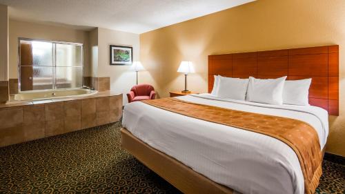 a hotel room with a large bed and a bath tub at Deluxe Inn Wytheville in Wytheville