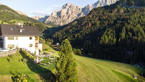 a house on a hill with mountains in the background at Lüch de Crusteles in La Valle