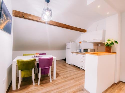 a kitchen with a table and chairs in a room at Apartman Aleksandar lux in Palić