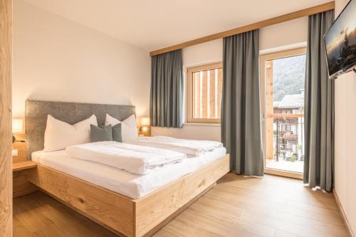 a bedroom with a large bed and a large window at Zeit.Glück Appartements in Radfeld
