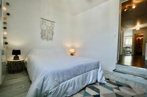 a bedroom with a white bed and a checkered floor at Appartement de l'Hippodrome avec deux chambres in Deauville