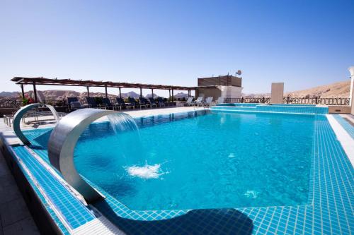 a swimming pool with a dolphin in the water at Petra Moon Luxury Hotel in Wadi Musa