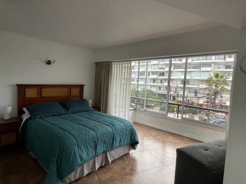 een slaapkamer met een bed en een groot raam bij Centromar 302 a pasos de todo in Viña del Mar