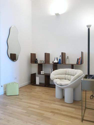 een woonkamer met een witte stoel en een tafel bij City Center Apartment Piacenza in Piacenza