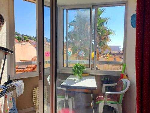 une table et des chaises dans une pièce avec une fenêtre dans l'établissement Coeur de Corniche, à Sète