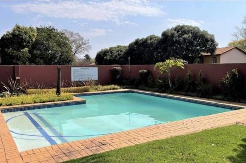 a swimming pool in the yard of a house at Upmarket 3 Bedroom Apartment in Johannesburg