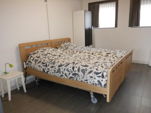 a bedroom with a bed with a black and white comforter at Hoeve Megusta in Vlimmeren