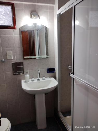 W łazience znajduje się biała umywalka i prysznic. w obiekcie Dpto céntrico con estacionamiento w mieście San Miguel de Tucumán