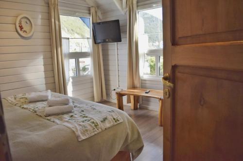 - une chambre avec un lit, une télévision et des fenêtres dans l'établissement Cabañas Las Marías, à San Martín de los Andes