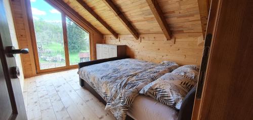 a bedroom with a bed in a log cabin at Vikendica Brvnara Marčetić in Banja Luka