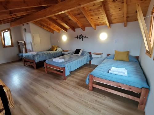 Sala de estar con 2 camas y mesa en Los Robles Patagonia en Esquel