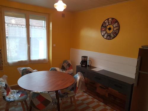 une salle à manger avec une table et une horloge au mur dans l'établissement Gite La maison d'Odette, à Saint-Georges-de-Mons