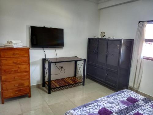 a bedroom with a bed and a tv and a dresser at Cabañas San Lorenzo in San Lorenzo