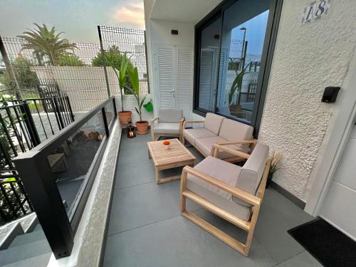 a balcony with chairs and a table on a building at Silver & Brownie, Nuevo apart cerca de la Playa in Playa de las Americas