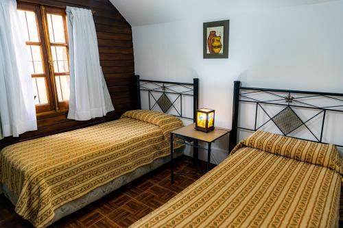 a bedroom with two beds and a table with a lamp at Cabañas San Lorenzo in San Lorenzo