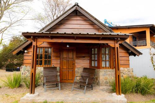 a small cabin with two chairs in front of it at Cabañas San Lorenzo in San Lorenzo