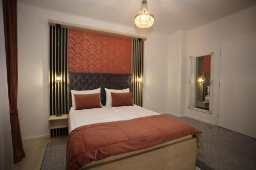 1 dormitorio con cama y lámpara de araña en Apartments Artee Free Garage Parking, en Sarajevo