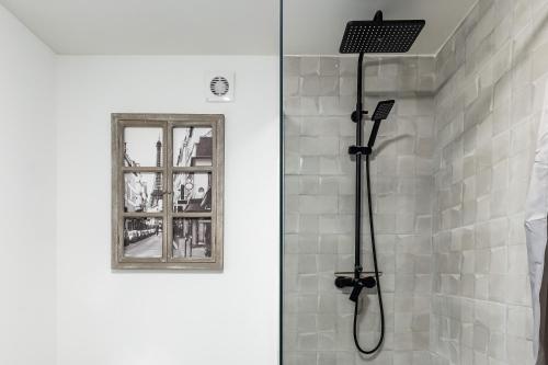 een douche met een douchekop in de badkamer bij Le 18-GregIMMO-Appart'Hôtel in Bavilliers