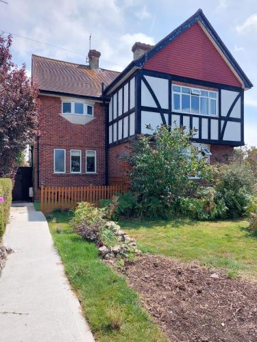 a red brick house with a black and white roof at spacious self-contained accommodation 135 cantebury road in Kent