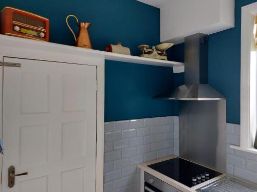 uma cozinha com paredes azuis e uma porta branca em spacious self-contained accommodation 135 cantebury road em Kent