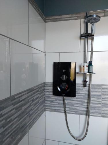 una doccia con tubo fissato a un muro di spacious self-contained accommodation 135 cantebury road a Kent