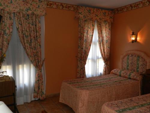 a bedroom with two beds and a window at Hotel Don Javier in Ronda