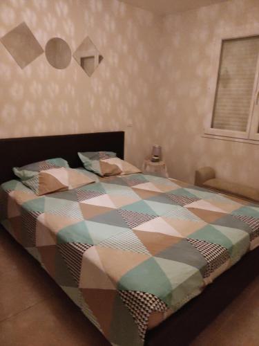 une chambre avec un lit avec une couette colorée dans l'établissement Chambre chez l'habitant, à Alignan-du-Vent