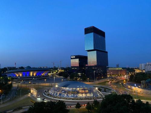 een uitzicht op een stad met een hoog gebouw in de nacht bij IX PIĘTRO - 9th floor apartment in Katowice in Katowice