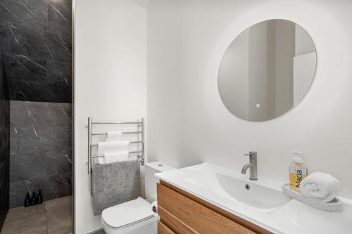 a white bathroom with a sink and a mirror at Nestled below the Remarkables in Queenstown