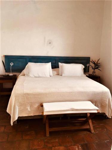 a bedroom with a large bed with a blue headboard at La Nube Posada in Barichara