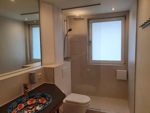 ein Badezimmer mit einem WC, einem Waschbecken und einem Spiegel in der Unterkunft Apartment Frankfurt City View - Oberursel in Oberursel