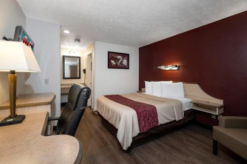 a small hotel room with a bed and a desk at Red Roof Inn Indianapolis - Greenwood in Greenwood