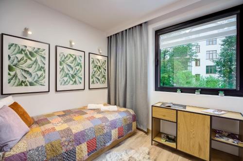 - une chambre avec un lit et une fenêtre dans l'établissement Jaśmin Apartamenty, à Krynica-Zdrój